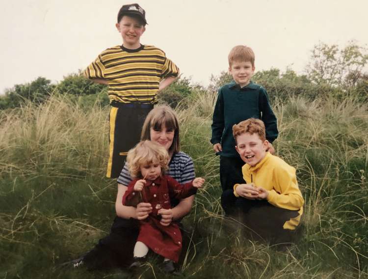 Kelly (bottom, red) and Michelle (holding Kelly) pictured at a Macclesfield reservoir. Also pictured is Michelle's younger brother Peter (black and yellow stripes), Kelly's brother Max (in the green) and Kelly's oldest brother Jack in the yellow.