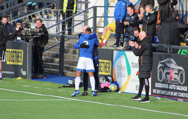 Macclesfield FC Assistant Manager hugs Danns as Silks Manager Danny Whitaker watches on.