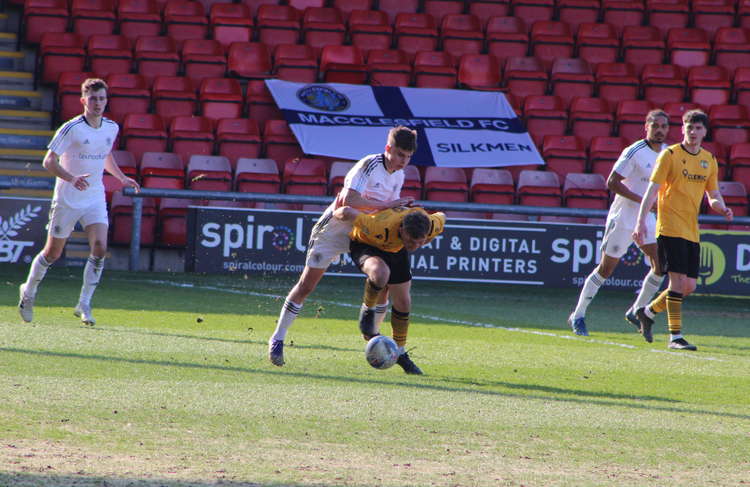 Macclesfield No. 8 Callum West is held back by a falling William Buckley.