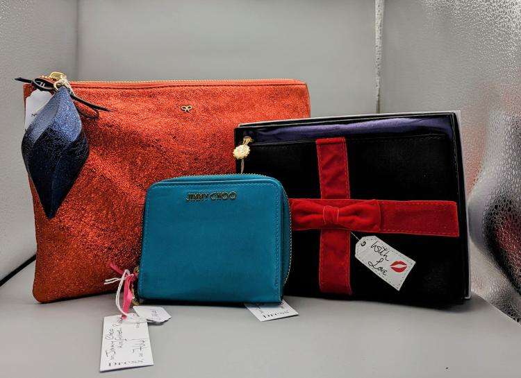 The first lot is JIMMY CHOO; a teal, kingfisher purse with gold logo and zip with two pockets, a Lulu Guiness make up bag, together with Anya Hindmarch striped tote bag and orange make up bag. Estimate £120. (Image - Adam Partridge)