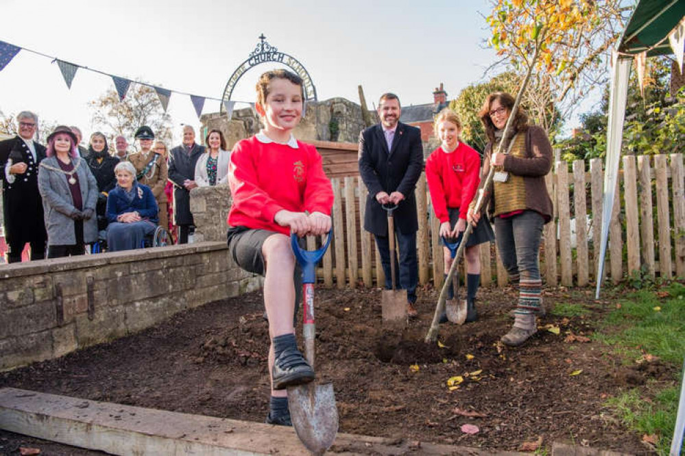 Children from Widcombe Junior School planting a pear tree with help from from Bath & North East Somerset Council leader Councillor Kevin Guy and outdoor play