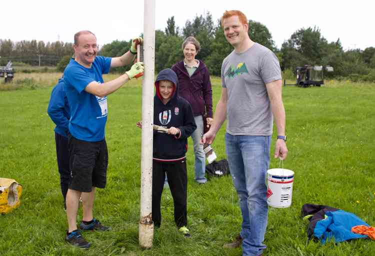 Volunteers help to clean and paint Helsby RUFC's goalposts