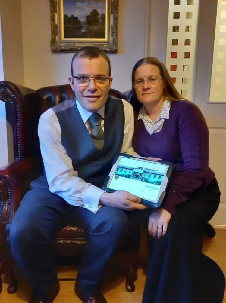 Andrew and Jenny Middleton with a framed photo the Zimbabwe school which they are fundraising for.