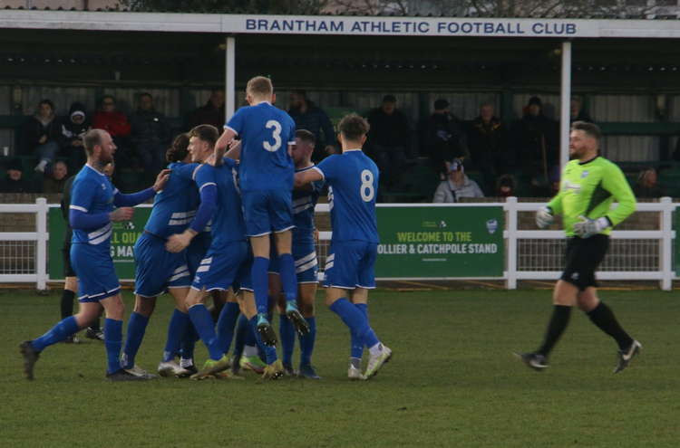 Goalscorer Tommy Northwood mobbed as Brantham celebrate his scorcher (Picture credit: Ian Evans/Nub News)