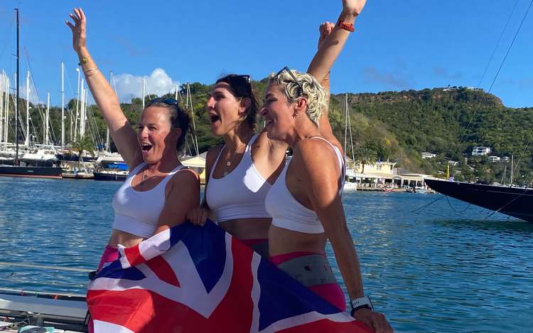 L to R: Abby Johnston, Charlotte Irving and Kat Cordiner cheer with the UK flag on their arrival to Antigua