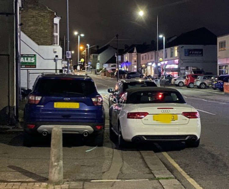 Cars double parked blocking the pavement and forcing pedestrians into the road - as well as obscuring vision on the approach to a pedestrian crossing