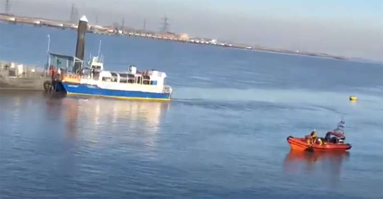 The man is pulled from the river while onlookers watch from the shore and the Tilbury-Gravesend ferry.