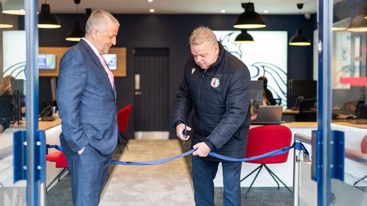 Steve Skinner cuts the ribbon watched by senior director Alan Webb.