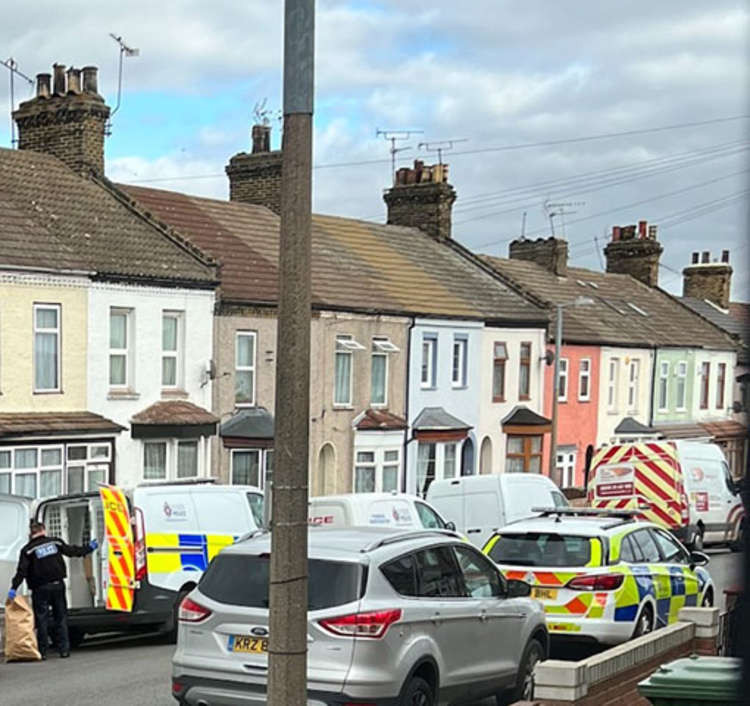 Police officers remove plants from the property