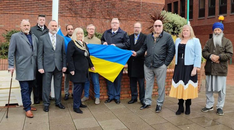 Councillors stand by the flag before it was raised.