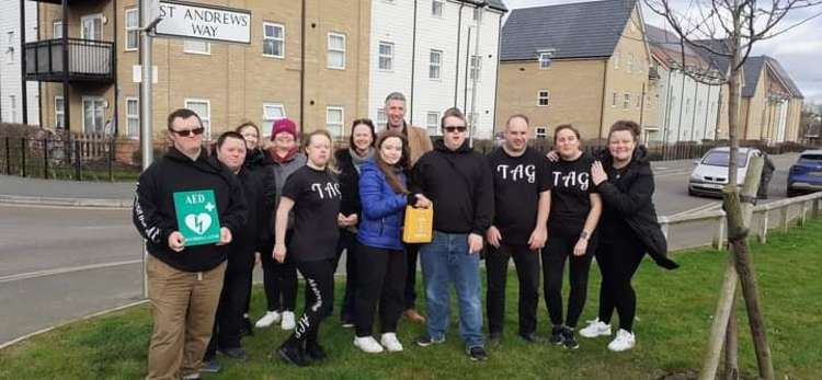 Katie Davies handing over a defib machine to the Ace Group.