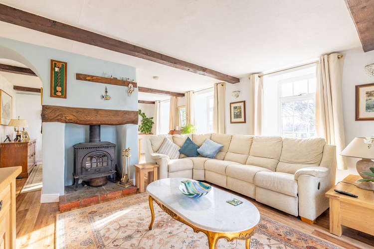 The living room and dining room are partly separated by a fireplace with wood burning stove