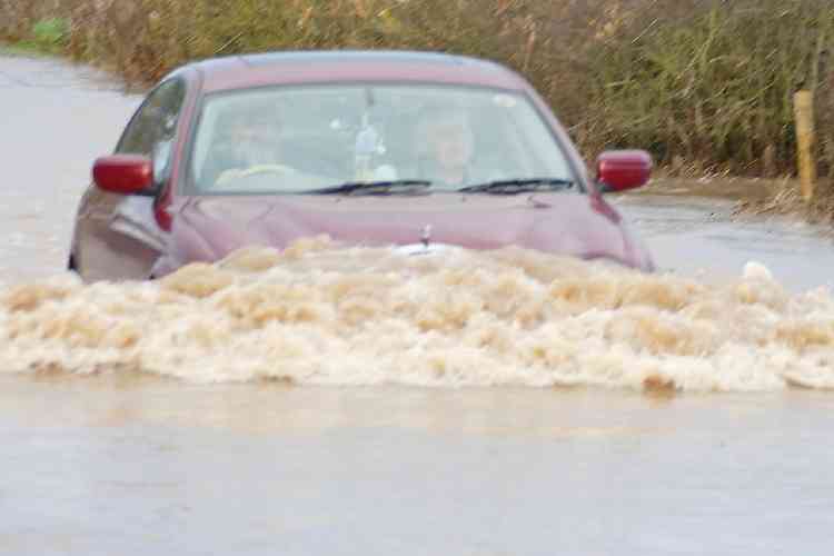 Water performance: A driver braves the floodwaters on Ratcliffe Road, Atherstone