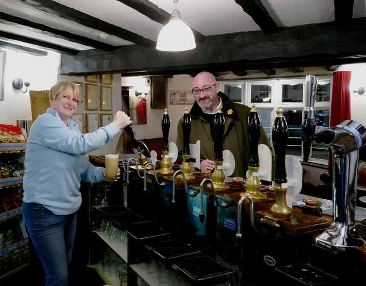 A pint of cheer: Angel landlady Carol Evans pulls a pint for a customer