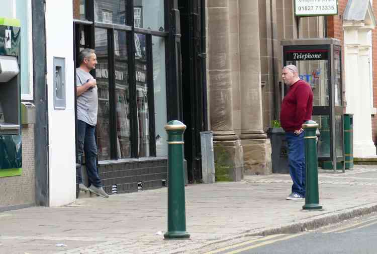 From a distance: Two men chat outside a closed Kerriann's