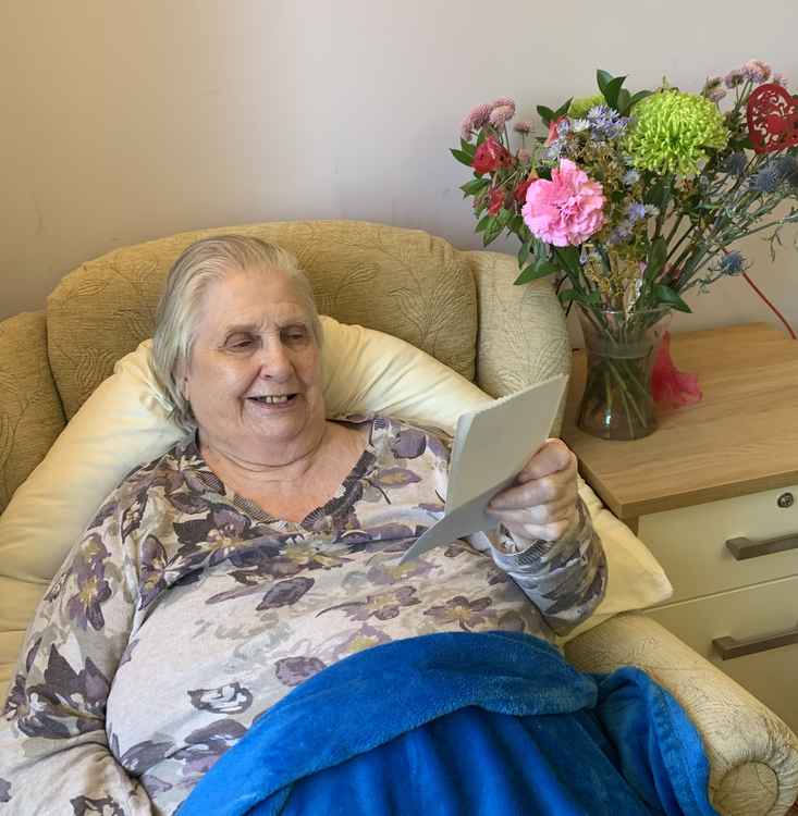 Wessex House resident Norma with a letter sent by a Millfield student