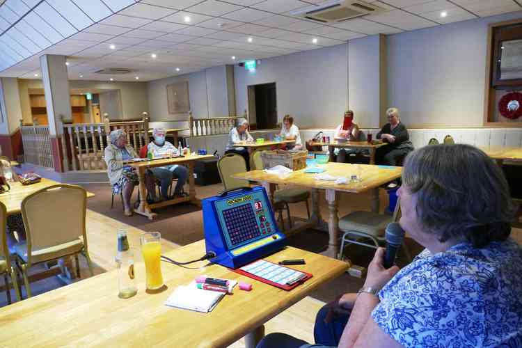 Socialising at a distance: Anne Taylor, foreground, calls out some lucky numbers