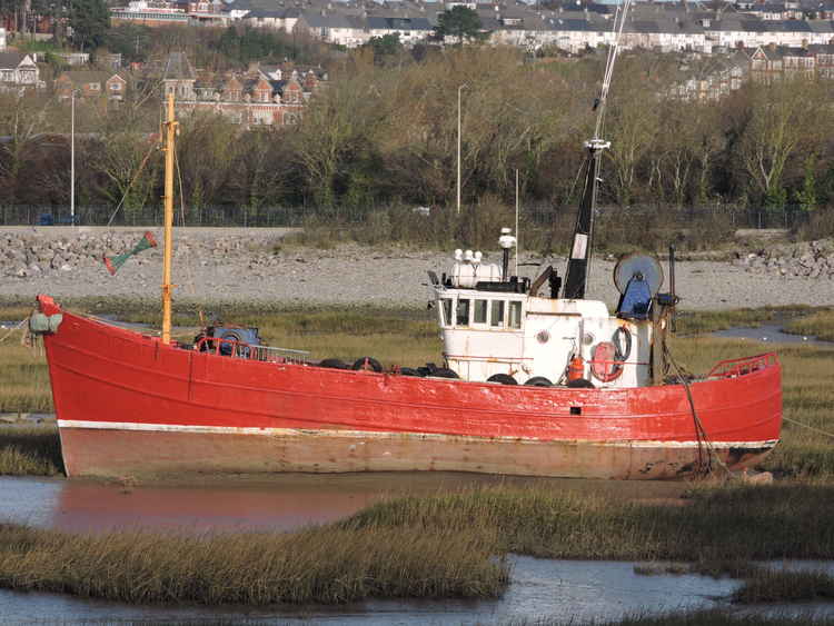 The red boat is currently moored in the mud at Barry Harbour