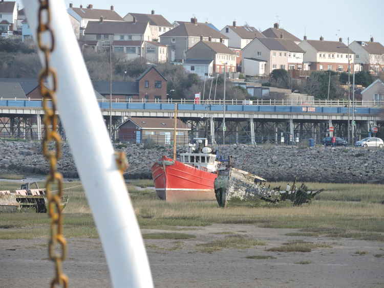 A view of the red fishing boat from the blue trawler