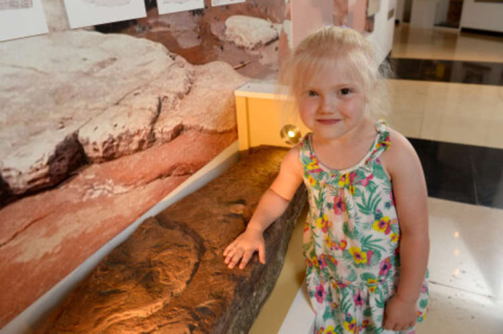 Lily Wilder (4 years old), who discovered the fossil at Bendricks Bay with the specimen in the Main Hall at National Museum Cardiff