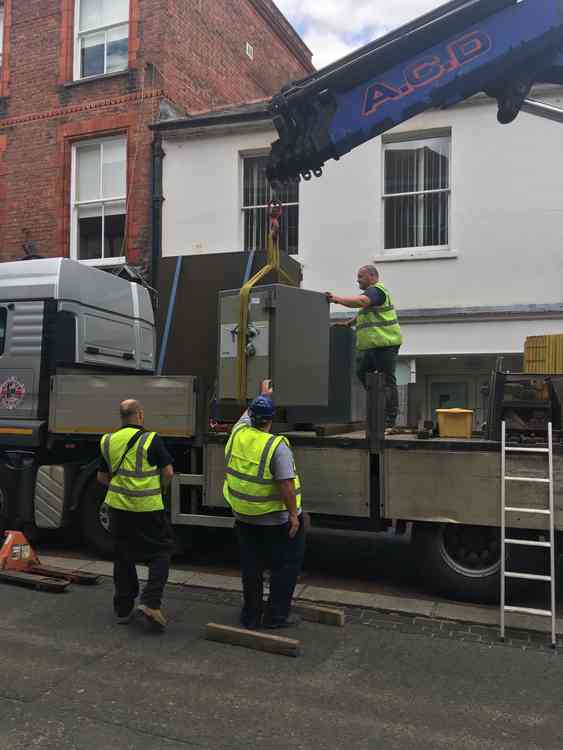 A safe is loaded onto a lorry.