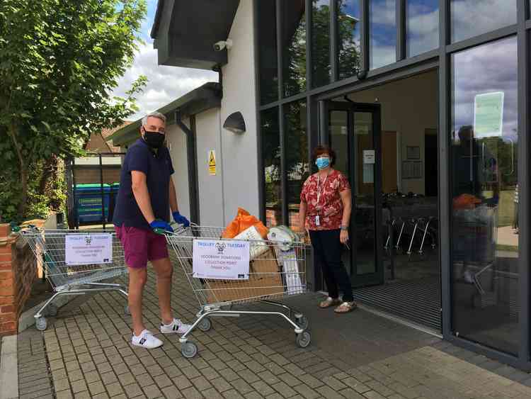 Patrick Andre and Karen Warner take delivery of another trolley-load of donations