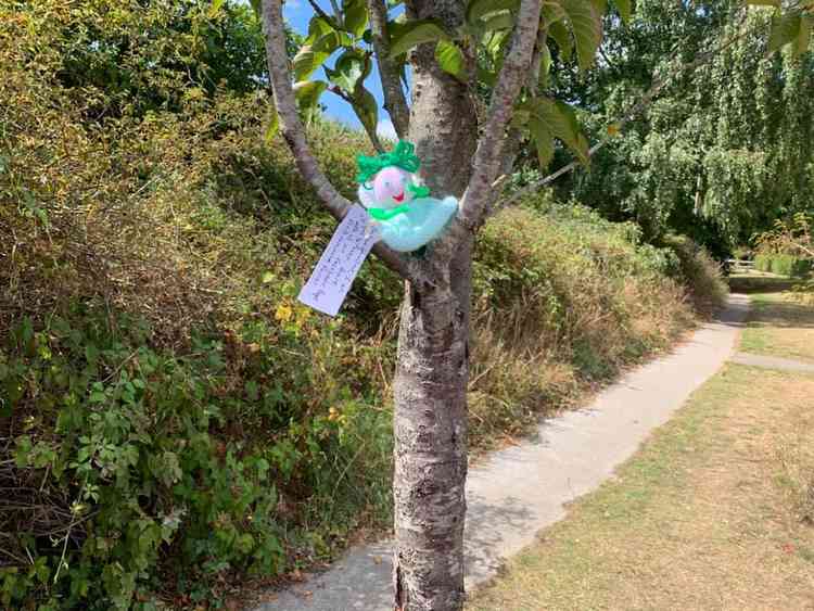 A fairy perches in a tree.