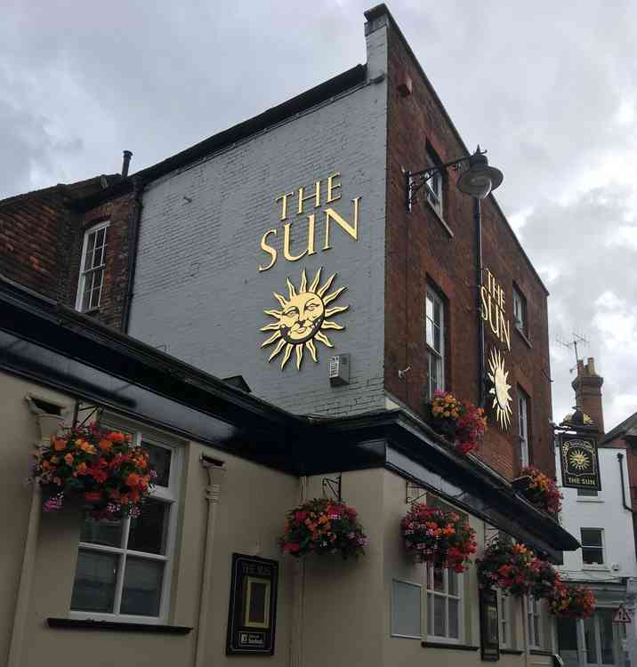 Hanging baskets and an impressive pub sign.