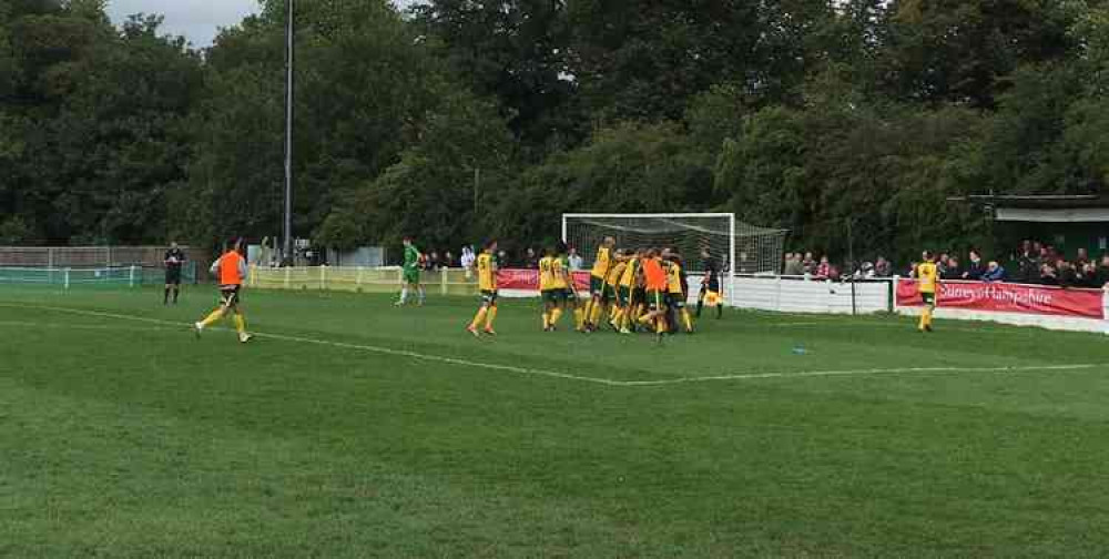 Godalming Town players celebrate after winning the penalty shootout.