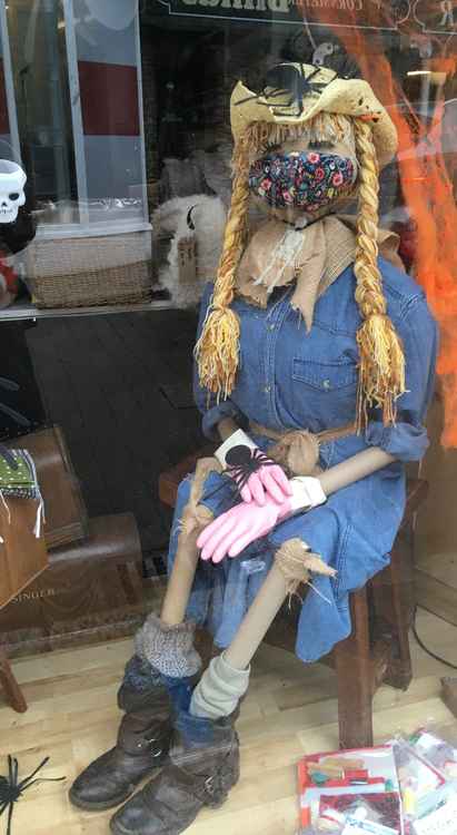 A scarecrow and spiders in the window at I Made This Crafts.