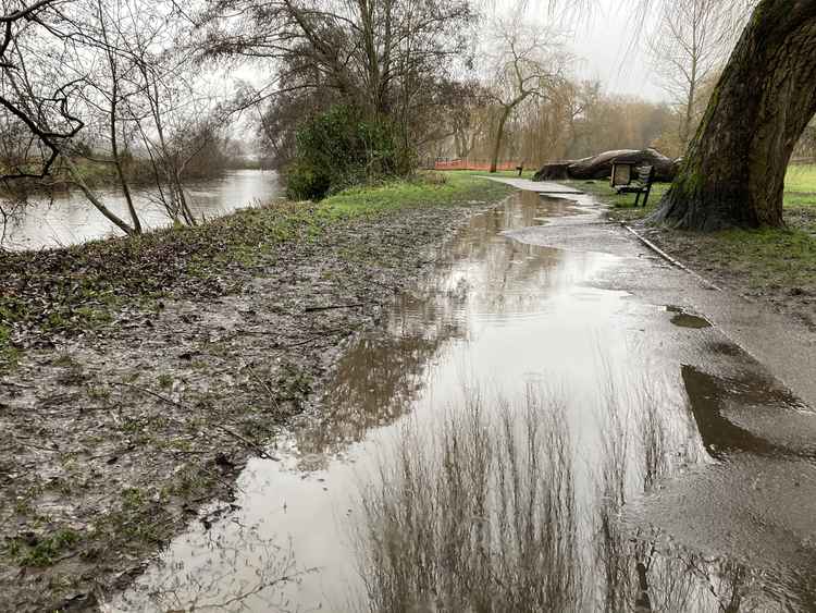 The riverside path is partly under water.