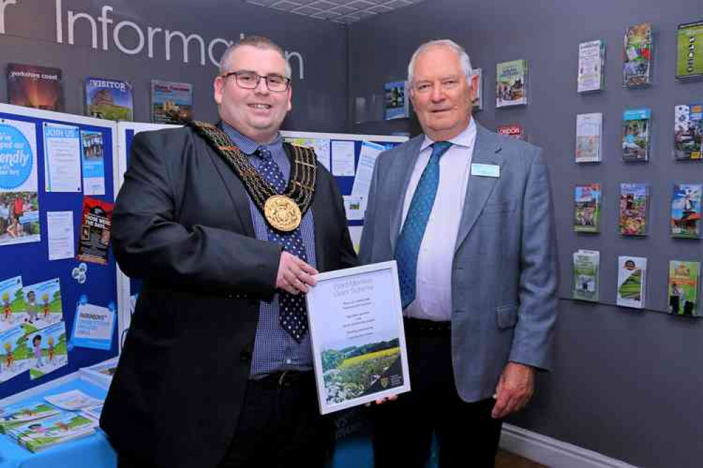 Town Mayor and SKDC Councillor Adam Stokes presents the grant certificate to Raymond Flack, Chairman of the Grantham Branch of Parkinson's UK.