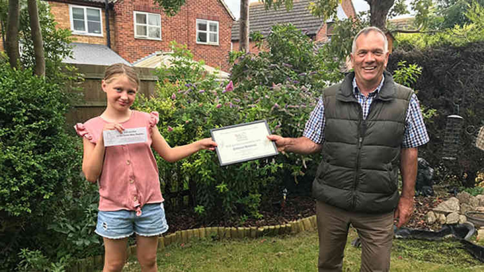 Garden expert John Stirland presents a certificate to Rebecca Shopland, winner of the Best Garden Created by Kids category in the Ropsley online garden competition.