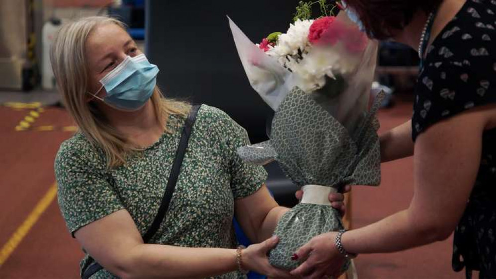 Lisa Szirtes, 42, from Sleaford, receives flowers from Rebecca Neno, Deputy Chief Nurse, NHS Lincolnshire CCG, in recognition of being the recipient of the one millionth covid vaccination (first and second doses combined).