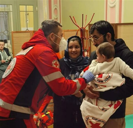 A Red Cross medic in Poland helps a newly-arrived family from Ukraine (The Masonic Charitable Foundation).