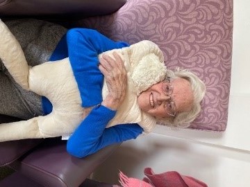 Joan Denning giving a loving hug to one of the dolls. (Image credit: Methodist Homes - MHA)