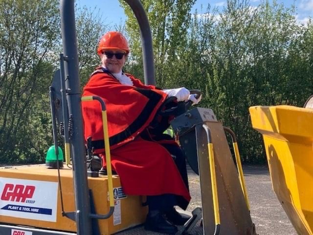 The Mayor of Axminster, Cllr Jill Farrow, drives the digger which broke ground for the new skatepark at Cloakham Lawns