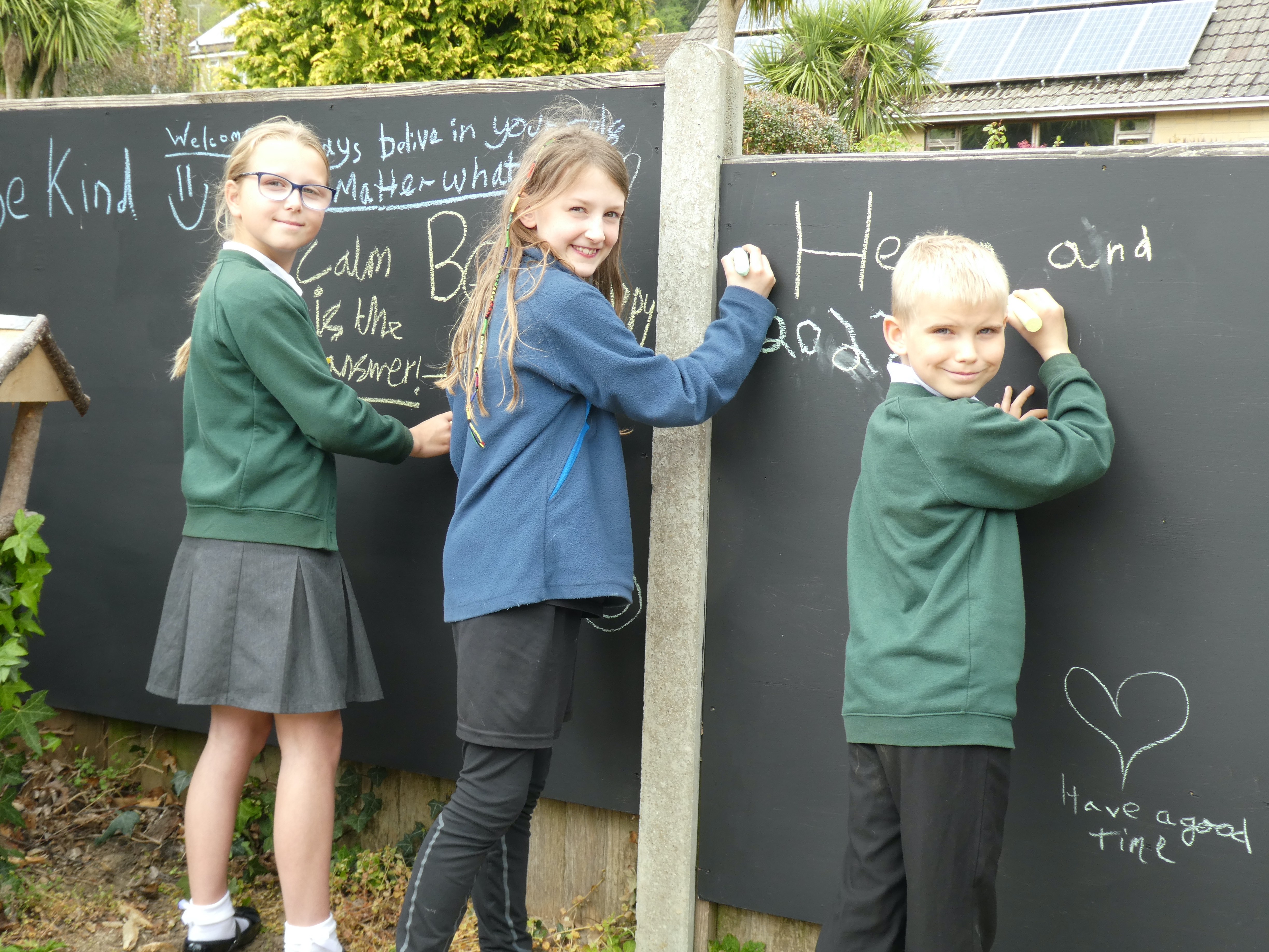 Children writing on the chalk boards