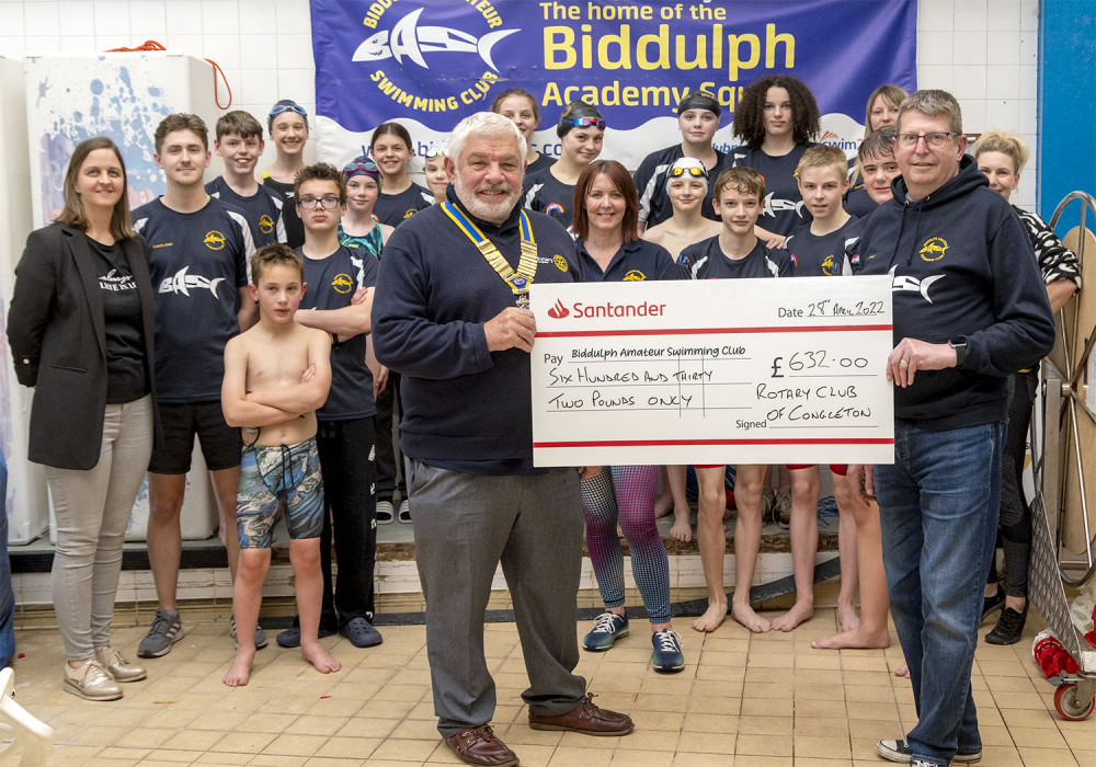 Congleton Rotary President Stew Price presents a cheque to Andy Plumley. Jane Bates (extreme left) and members of the swimming teams are in the picture.