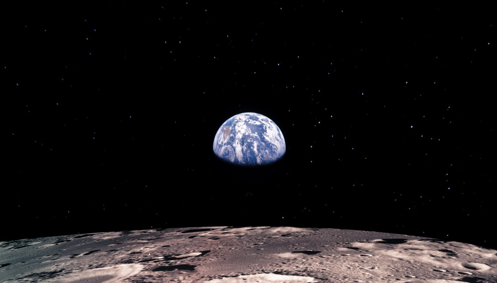 Earth rises above lunar horizon; a view beyond imagining less than a century ago
