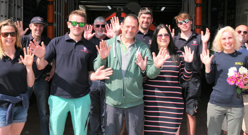 Justin and his sister Janine (centre) met with members of the lifeboat crew after the rescue and made a generous donation to the RNLI. They are waving their hands which is a known reaction to photographs by those with hearing impairments who use British Sign Language