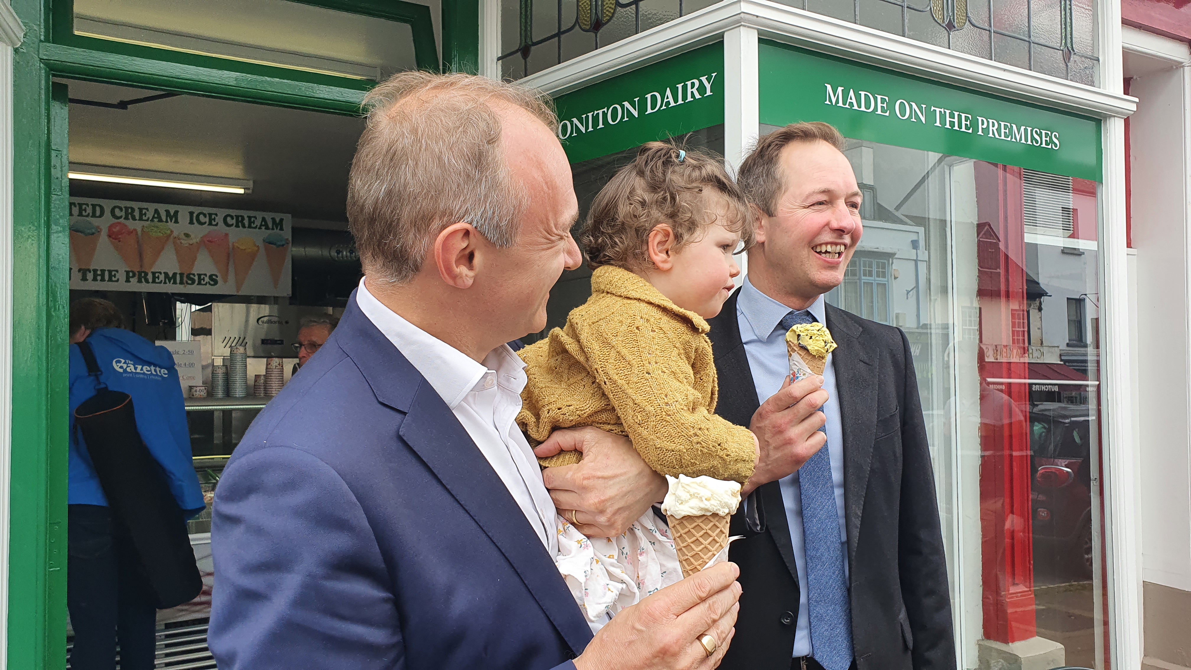 Ed Davey and Richard Foord holding a Liberal Democrat supporter's child 