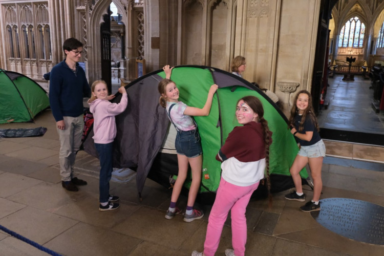 Girl choristers set up tent in the Cathedral