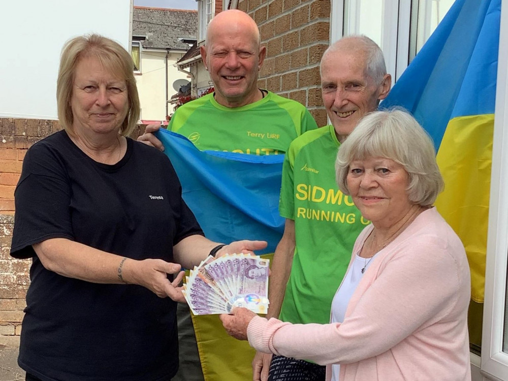 Teresa Loynd, left, receiving the donation from Brenda Perratt, right, with SRCs' Terry Bewes and Rob Edwards (Sidmouth Running Club)