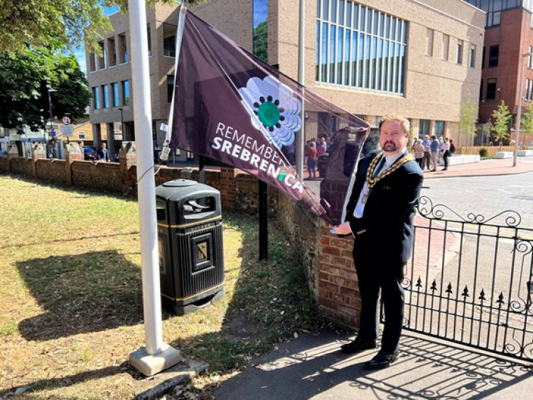 Cllr James Halden raises the flag.