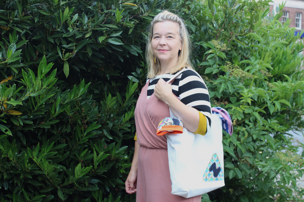 Zoë Aspinall turns waste fabric into trendy, colourful products. Peeking out of her tote bag are some of her sustainably-sewn clothes. (Image - Alexander Greensmith / Macclesfield Nub News)