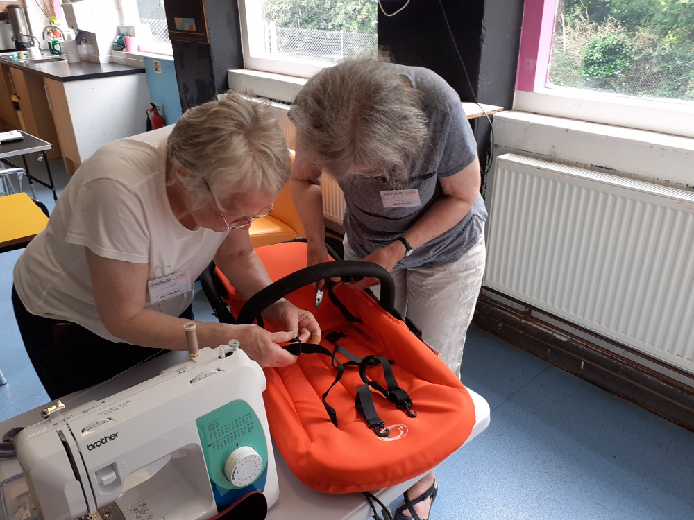 A fixer helps fix a pram at last month's Repair Café (Credit: Jim Rider)