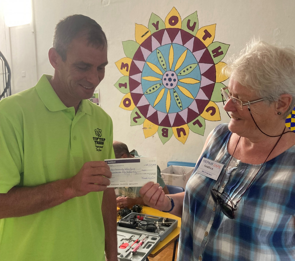 Sean of Tip Top Trees presenting cheque to Sheena King, the Repair Cafe's Treasurer. (Credit: Miriam Thomas)
