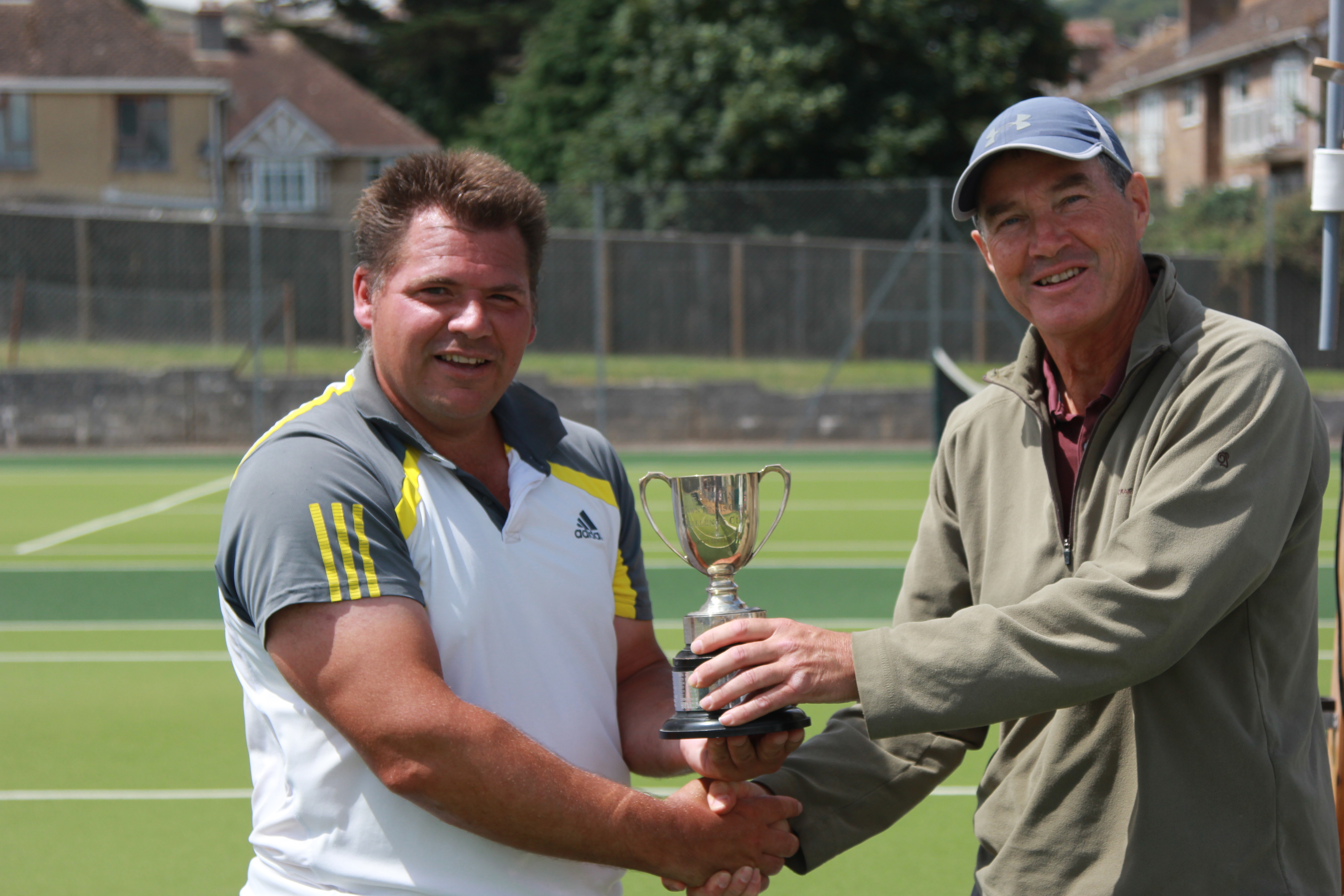 Club chairman Simon Prior presents the men's singles trophy to Kevin Daniels