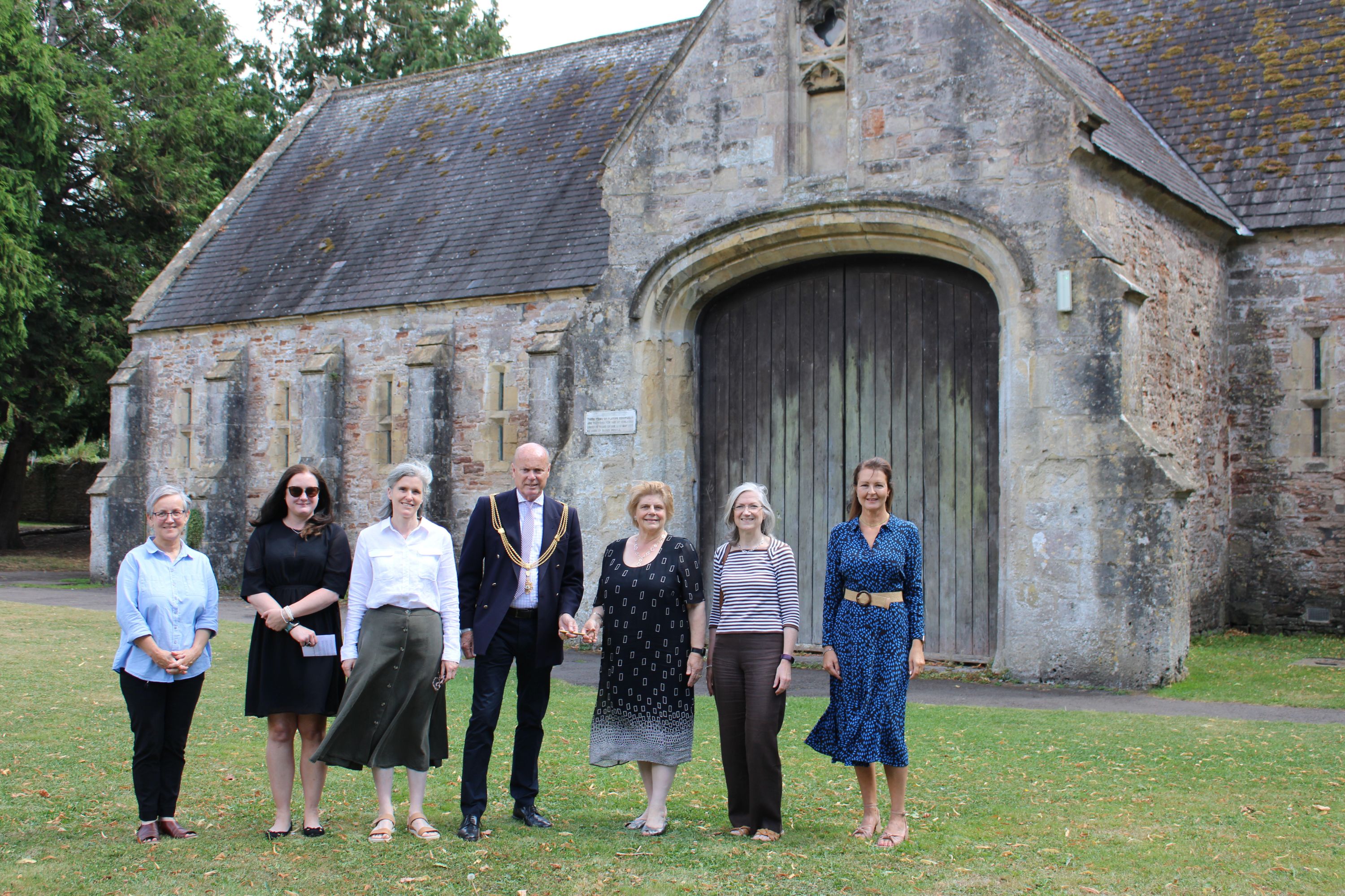 Representatives from Mendip District Council and Wells City Council outside the Bishop's Barn, Wells